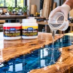 Clear epoxy resin being poured onto a live-edge wood table for a glossy river table finish.toolstationpakistan, tollstation.com