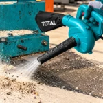 TOTAL handheld electric blower with black nozzle and dust collection bag clearing dust and debris from a concrete surfacetoolstationpakistan, toolstation.com