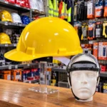 Yellow safety hard hats stacked on a wooden table at a construction workplacetoolstationpakistan, toolstation.com